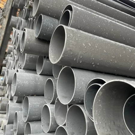 Photo d'une pille de tuyaux d'evacuation en pvc. Ces tuyaux comporte des gouttes due à la pluie. Stock de la quincaillerie.